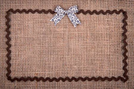 Retro bow and ribbon on burlap background.の写真素材