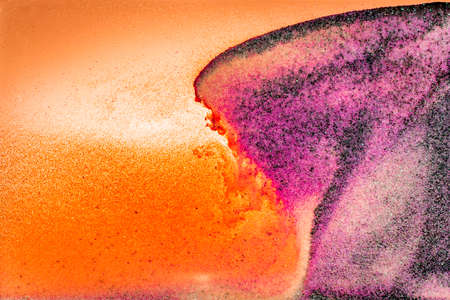 Colorful sand pigments falling down in water. Abstract landscape background.