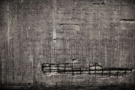 Concrete devastated wall with visible rebar.
