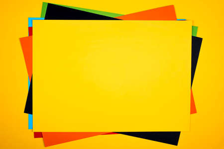 Colorful paper sheets stack on yellow background.の写真素材
