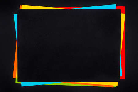 Colorful paper sheets stack on black background.の写真素材