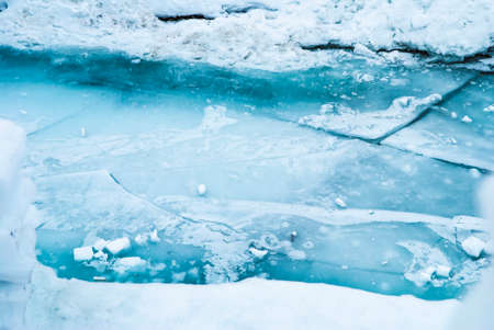 Large blue cracked ice surface on the river.の写真素材