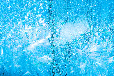 Abstract winter background - blue frozen window outdoors