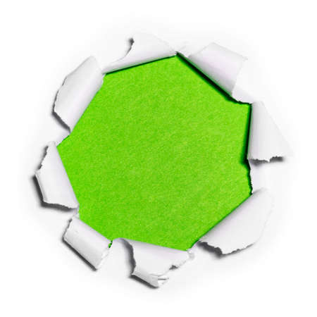 Paper hole in white paper with ragged edges with green background.の写真素材