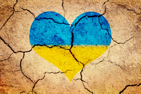 Textured background of cracked dry brown earth with Heart in Ukrainian Flag Colorsの写真素材