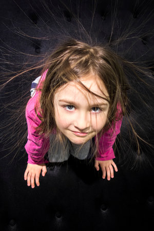Young girl with hair standing up full of static electricity.の写真素材