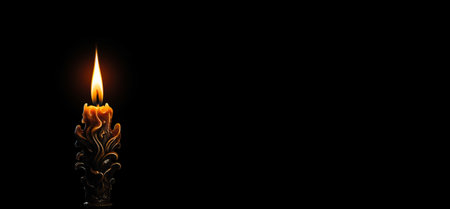 Decorative Candle Burning in Dark Against Black Backgroundの素材
