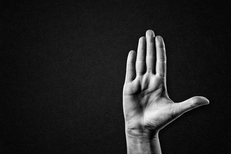 Hand Gesture Stop Sign in Black and White on Textured Paper Background, Copy Spaceの写真素材
