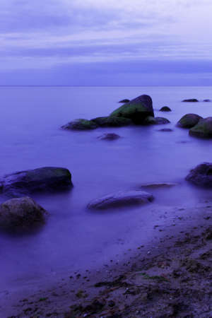 Morning light on the water, on the beach with stones の写真素材