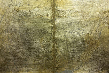 Old gilded surface with cracks and flaking and abrasions.の写真素材