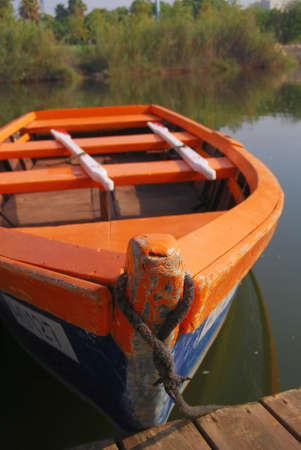 old wooden boat beside pier with two white oarの写真素材