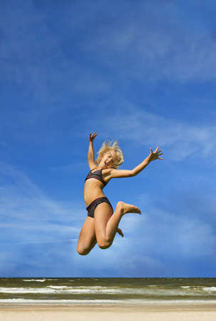 jumping girl on the beachの写真素材