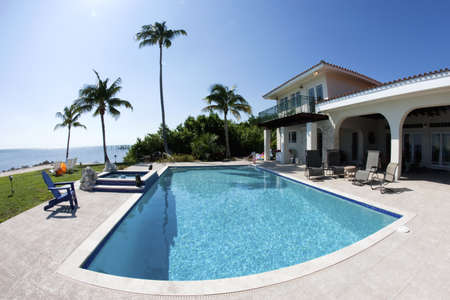 Beautiful swimming pool with palm tree and a house in tha Floridaのeditorial素材