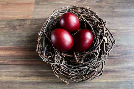 Easter eggs in the nest on a wooden background