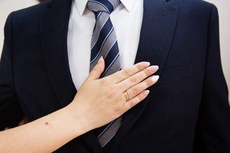 Wedding boutonniere on suit of groom and bride's handの写真素材