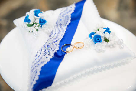 Gold wedding rings on the pillowの写真素材