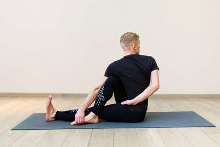 Sporty man practicing yoga on yoga class