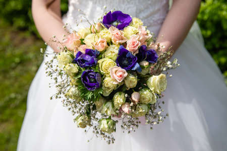 Beautiful wedding bouquet of flowers in the hands of the brideの写真素材
