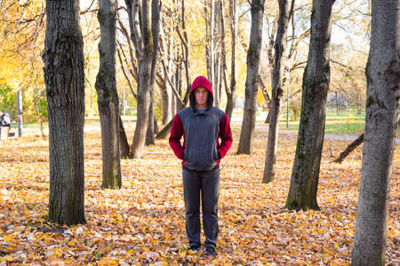Young man walking in autumn parkの写真素材