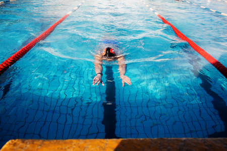 Professional male swimmer swimming in the poolの写真素材