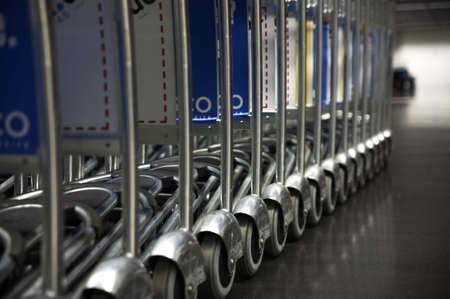 a long row of airport luggage trolleys の写真素材