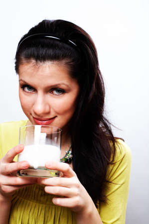 young beautiful causacian woman with glass of milkの写真素材