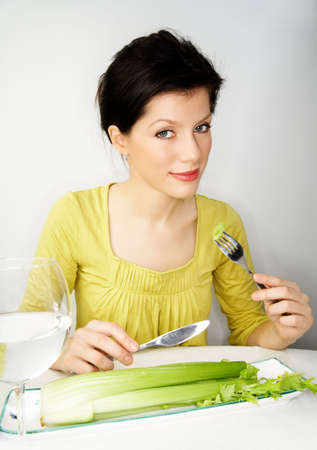young woman having her breakfast with water and celeryの写真素材