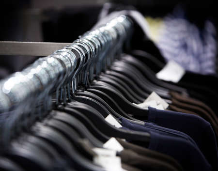 a row of clothes on hangers in the shopの写真素材