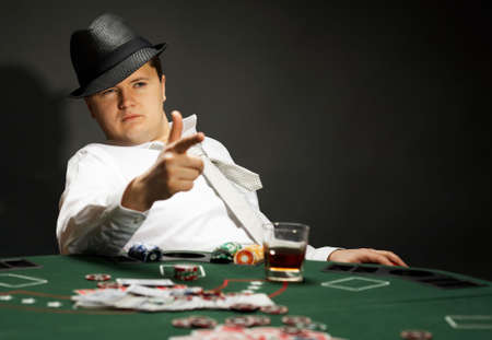 man wearing hat is playing poker in casinoの写真素材