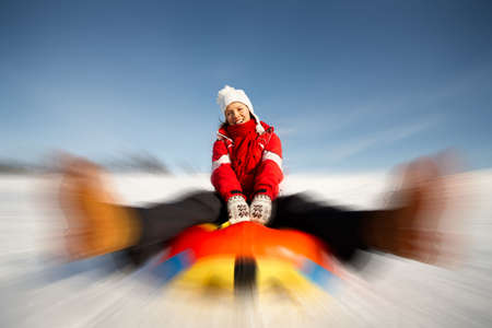 caucasian woman is sliding fast downhill on an inner tubeの写真素材