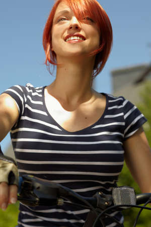 adult smiling biker woman on mounting bike の写真素材