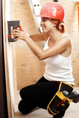 caucasian woman as worker wearing red protective helmetの写真素材