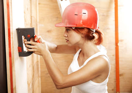 caucasian woman as worker wearing red protective helmetの写真素材