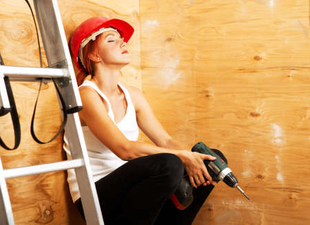 caucasian woman as worker wearing red protective helmetの写真素材