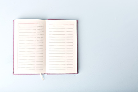 opened notebook on blue table, flat lay