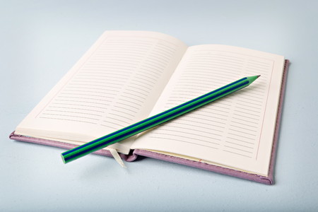 opened notebook on blue table, flat layの写真素材