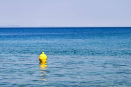 yellow buoy floating on the seaの写真素材