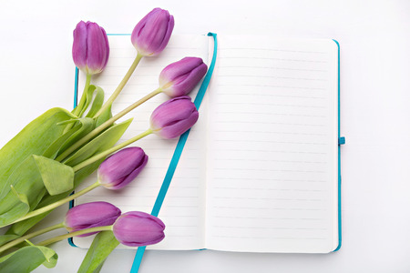 Flat lay - desk with notebook and flowersの写真素材