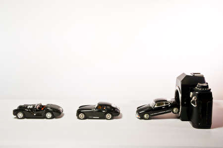 A black toy car comes out of a black camera.の写真素材