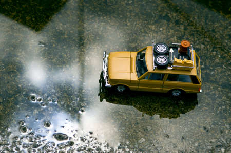 Yellow off-road running through city streets with a little water after rain.の写真素材