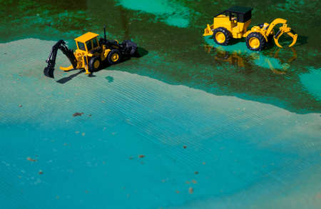 Two forklifts, put into the green zone construction upstream of the river.の写真素材