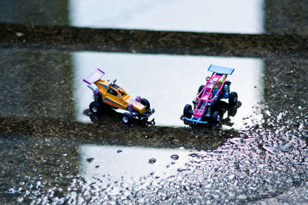 Two small offroad toy cars are facing each other.の写真素材