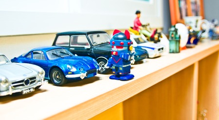 A blue robot standing in front of a blue car toy in a showcase.の写真素材