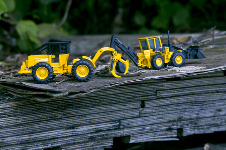 There are two large forklift trucks on wooden boards stacked in the open woods.の写真素材