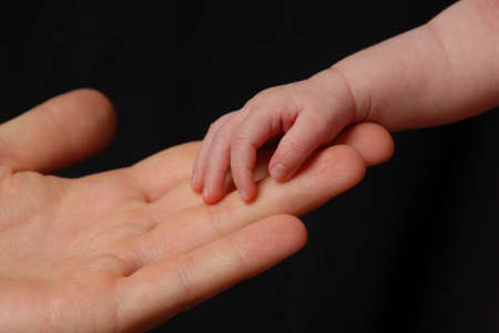 Baby hand lies in parents handsの写真素材