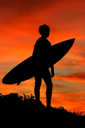 A silhouette of a surfer looking out to sea