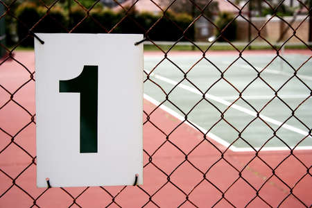 A number one sign on the fence of a tennis courtの写真素材