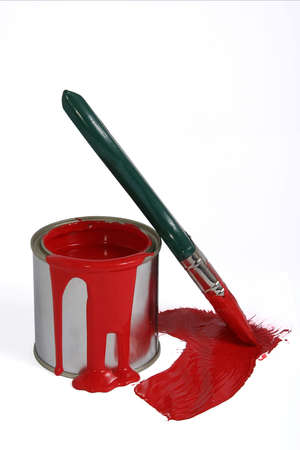 Tin of opened red paint with a brush with green handle on white backgroundの写真素材