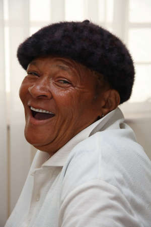An African senior woman with a hat on and laughingの写真素材