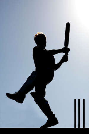 Silhouette of a cricket player playing a pull shotの写真素材
